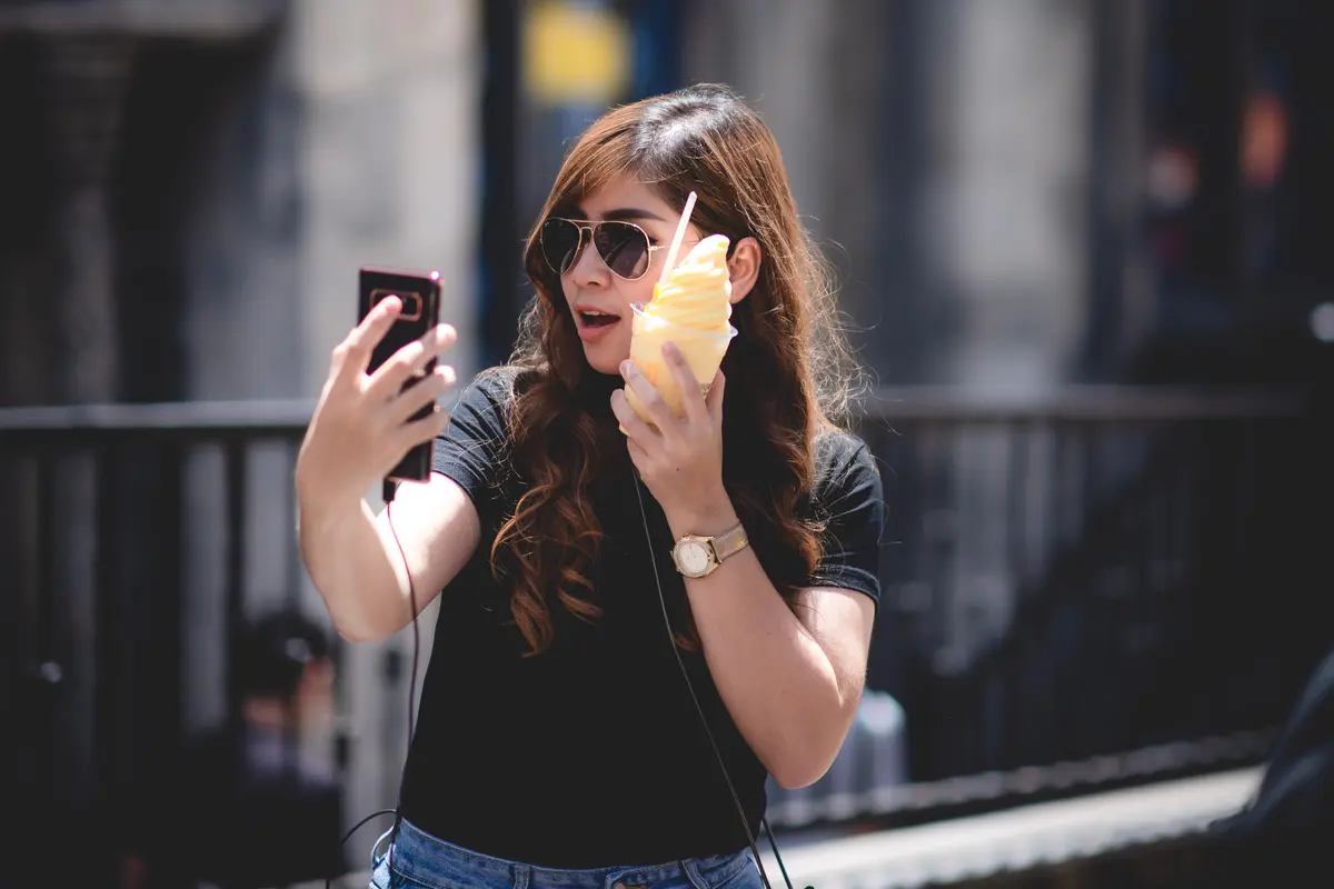 perempuan memegang smartphone