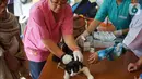 Petugas kesehatan hewan memberikan vaksin rabies pada kucing di kawasan Sawah Besar, Jakarta, Kamis (3/9/2019). Dalam rangka memperingati Hari Rabies Sedunia, Sudin Ketahanan Pangan Kelautan dan Perikanan DKI Jakarta melakukan vaksinasi hewan secara gratis. (Liputan6.com/Immanuel Antonius)