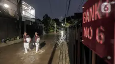 Warga melewati rumah yang tergenang banjir di jalan Bank, Jakarta Selatan, Selasa (4/10/2022). Hujan yang mengguyur wilayah Ibu Kota Jakarta mengakibatkan banjir menggenangi kawasan Kemang, Jakarta. (Liputan6.com/Johan Tallo)
