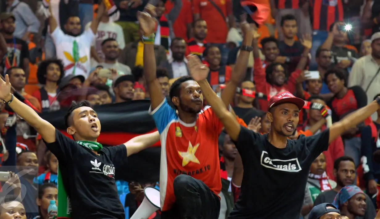 Suporter Persipura bersorak saat menyaksikan laga melawan melawan PS TNI di lanjutan Torabika Soccer Championship presented by IM3 Ooredoo di Stadion Pakansari Kab Bogor, Minggu (19/6). Persipura unggul 3-1. (Liputan6.com/Helmi Fithriansyah)