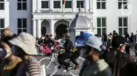 Warga bersepeda saat menikmati libur Lebaran di kawasan Kota Tua, Jakarta, Sabtu (7/5/2022). Akhir libur Idul Fitri, sejumlah kawasan wisata di Jakarta dipadati pengunjung untuk menghabiskan masa liburannya bersama keluarga dan Kota Tua masih menjadi salah satu destinasi wisata yang digemari warga DKI Jakarta dan sekitarnya. (Liputan6.com/Johan Tallo)