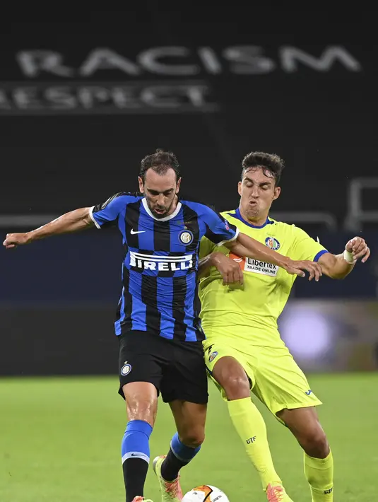 Bek Inter Milan, Diego Godin berebut bola dengan pemain Getafe, Jaime Mata pada pertandingan babak 16 besar Liga Europa di Veltins-Arena di Gelsenkirchen, Jerman, Rabu, (5/8/2020). Inter menang 2-0 atas Getafe dan melaju ke perempat final.  (AP Photo/Ina Fassbender)