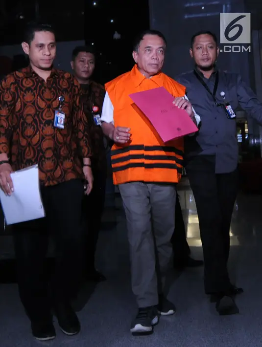 Gubernur Aceh, Irwandi Yusuf berjalan keluar mengenakan rompi oranye seusai pemeriksaan di gedung KPK, Jakarta, Kamis (5/7). KPK resmi menahan Irwandi Yusuf setelah ditetapkan sebagai tersangka kasus suap ijon proyek di Aceh. (Merdeka.com/Dwi Narwoko)