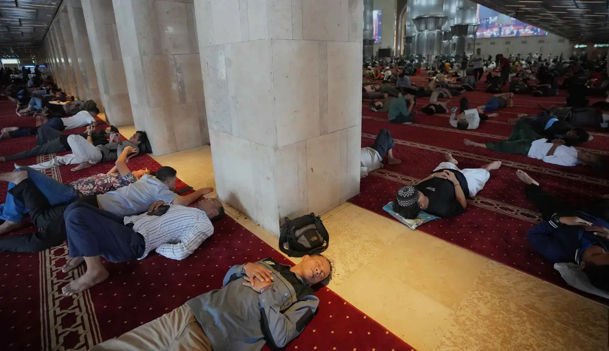 Ribuan umat Muslim memadati masjid yang di tengah kota Jakarta. Tampak dalam foto, Umat Muslim beristirahat setelah salat Jumat pertama bulan puasa Ramadan di Masjid Istiqlal di Jakarta, Jumat 20 Februari 2026. (AP Photo/Tatan Syuflana)