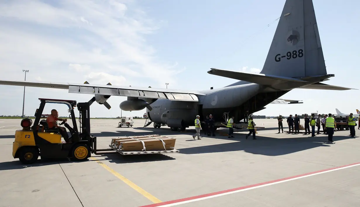 Menggunakan forklift, salah satu pekerja memasukkan peti mati korban jatuhnya pesawat Malaysia Airlines MH-17 di Bandara Kharkiv, (23/7/2014). (REUTERS/Gleb Garanich)