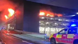 Foto-foto yang diambil dari lokasi kejadian menunjukkan kobaran api yang sangat besar menyapu bangunan yang terletak tidak jauh dari terminal bandara. (HO/Bedfordshire Fire and Rescue Service/AFPTV/AFP)