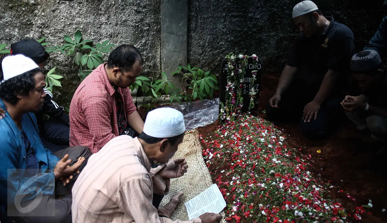Para kerabat berdoa disamping makam alm Guntoro di Lenteng Agung, Jakarta, Kamis (16/2). Diduga terkena serangan jantung , Guntoro, wartawan foto, Koran Jakarta meninggal dunia saat meliput banjir di daerah Pejaten Timur. (Liputan6.com/Faizal Fanani)