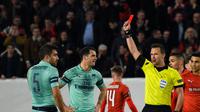Wasit Ivan Kruzliac mengeluarkan kartu merah untuk Sokratis pada leg 1, babak 16 besar Liga Europa yang berlangsung di Stadion Roazhon Park, Rennes, Jumat (8/3). Arsenal kalah 1-3 kontra Rennes. (AFP/Damien Meyer)