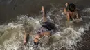 Anak-anak mandi di sungai Rio de la Plata untuk mendinginkan diri dari suhu tinggi di Buenos Aires, Argentina, Kamis, 2 Maret 2023. Gelombang panas datang di tengah-tengah pemadaman listrik  pada hari Rabu yang menyebabkan sekitar 40% keluarga di negara itu tanpa listrik selama berjam-jam. (AP Photo/Rodrigo Abd)