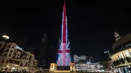 Sebuah potret Ratu Elizabeth II yang ditumpangkan dengan Bendera Britania Raya The Union Jack diproyeksikan di Burj Khalifa, gedung tertinggi di dunia, di Dubai, Uni Emirat Arab, Minggu (11/9/2022). Orang-orang di seluruh dunia memberikan penghormatan mereka kepada Ratu Elizabeth II, Raja Inggris yang paling lama memerintah selama 70 tahun. (Ryan LIM / AFP)
