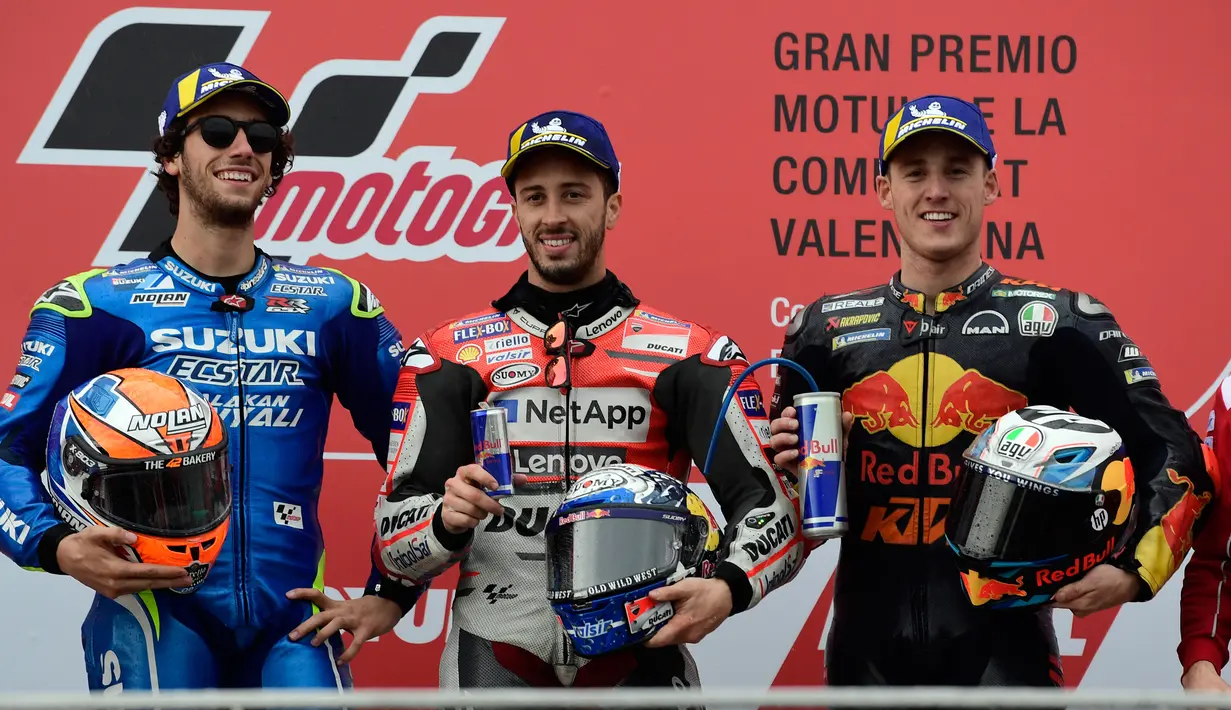 Pebalap Ducati, Andrea Dovizioso (tengah), pebalap Suzuki, Alex Rins dan pebalap Red Bull, Pol Espargaro merayakan kemenangan di podium usai balapan MotoGP Grand Prix Valencia di arena balap Ricardo Tormo, Cheste, Minggu (18/11). (Jose Jordan/AFP)
