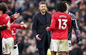 Pelatih kepala Manchester United, Michael Carrick, di tengah, menyapa Patrick Dorgu dari Manchester United setelah pertandingan Liga Inggris antara Manchester United dan Manchester City di Manchester, Inggris, Sabtu, 17 Januari 2026. (AP Photo/Dave Thompson)