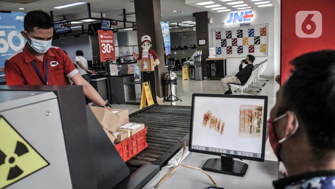 Petugas memasukkan paket ke dalam mesin X-Ray sebelum dikirim melalui jasa ekspedisi JNE di Tomang, Jakarta, Selasa (29/12/2020). Penggunaan jasa ekspedisi atau kurir meningkat hingga 85 persen selama pandemi COVID-19. (merdeka.com/Iqbal S. Nugroho)