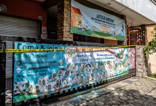 Gerbang pusat penitipan anak Little Aresha, disegel dengan garis polisi setelah adanya dugaan penganiayaan anak, di salah satu pusat penitipan, Yogyakarta pada Senin 27 April 2026. (DEVI RAHMAN/AFP)