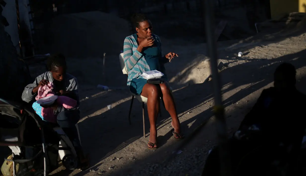 Seorang wanita hamil sedang makan dan disebelahnya seorang ibu menyusui bayi di penampungan Padre Chava, Tijuana, Senin (3/10). Setelah meninggalkan Brasil, di mana mereka pindah pasca gempa Haiti 2010, dan memutuskan pindah ke AS (REUTERS/Edgard Garrido)