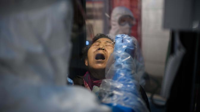 Seorang wanita mendapat test swab virus corona COVID-19 di luar Rumah Sakit Yangji, Seoul, Korea Selatan, 17 Maret 2020. Jumlah pasien virus corona COVID-19 di Korea Selatan mencapai 8.799 kasus dengan 102 meninggal. (Photo by Ed JONES/AFP)