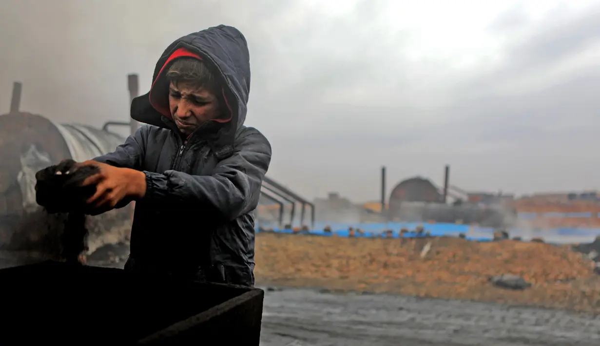 Amer al-Shayban (12) dari Suriah bekerja di kilang minyak darurat dekat Kota al-Bab yang dikuasai Turki, Suriah, 20 November 2021. Sebanyak 1,6 juta anak Suriah juga berisiko putus sekolah. (Bakr ALKASEM/AFP)