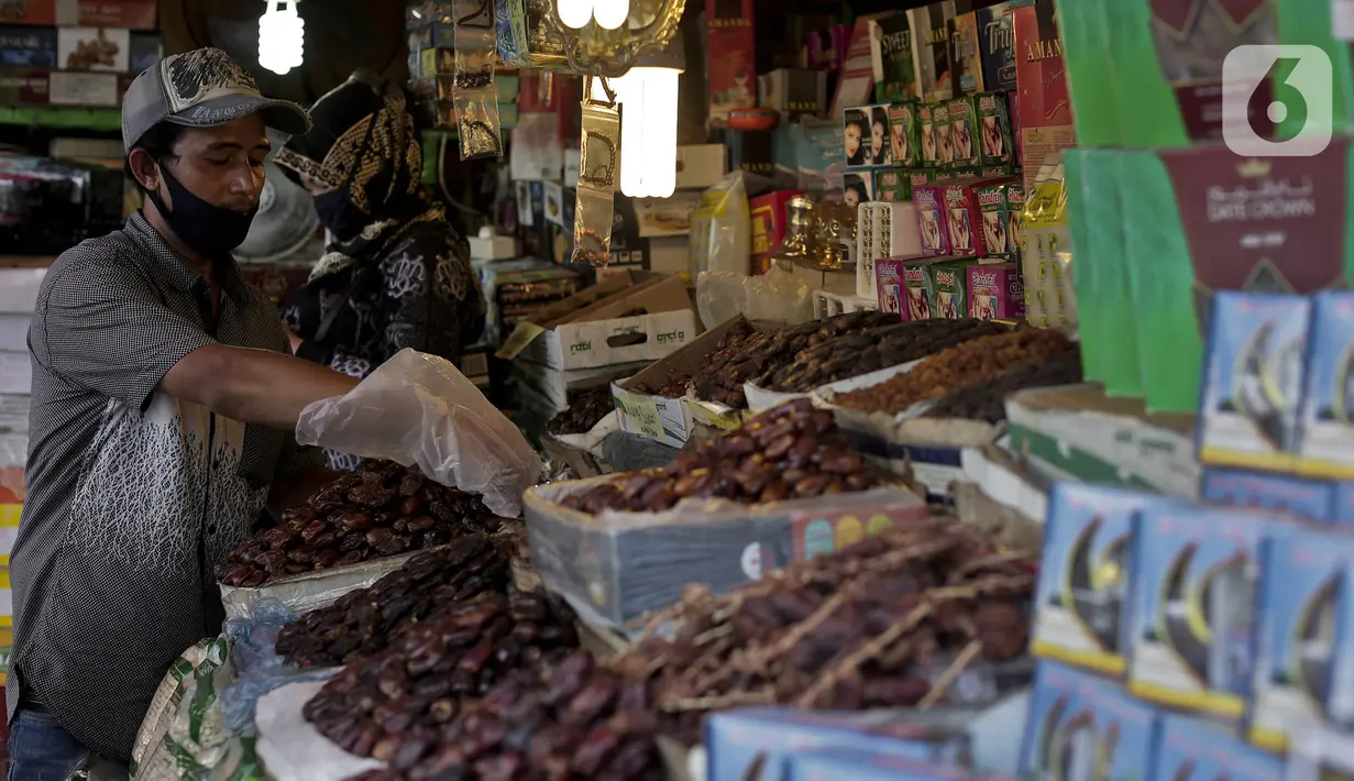 Pedagang menata kurma dagangannya di Pasar Tanah Abang, Jakarta, Rabu (22/4/2020). Pandemi COVID-19 membuat lesu penjualan kurma, keuntungan pedagang menurun hingga 80 persen lebih padahal pada tahun sebelumnya menjelang Ramadan biasanya ramai pembeli. (Liputan6.com/Johan Tallo)