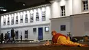 Seorang wanita tunawisma bersiap untuk tidur atas trotoar saat malam dengan cuaca dingin di pusat kota Sao Paulo, 19 Juli 2017. Menurut pejabat setempat, setidaknya 16.000 tunawisma tinggal di kota Sao Paulo. (AP Photo / Andre Penner)