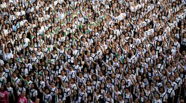 Ribuan siswa St. Scholastica College mengacungkan jari telunjuk "nomor satu" saat menari massal dalam aksi One Billion Rising di Filipina, Senin (15/2). Gerakan ini bentuk kampanye untuk menghentikan kekerasan terhadap perempuan. (AFP PHOTO/Noel CELIS)