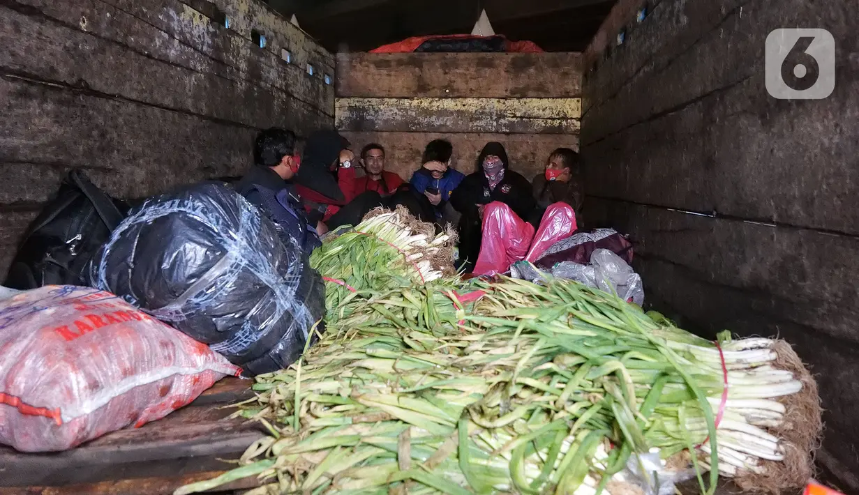 Pemudik berada di dalam truk saat pemeriksaan dokumen di Pintu Tol keluar Cikarang Barat, kabupaten Bekasi, Jawa Barat, Kamis (6/5/2021) dini hari. Pemeriksaan sebagai upaya mengantisipasi risiko peningkatan kasus penularan COVID-19 jelang Hari Raya Idul Fitri 1442 H. (Liputan6.com/Herman Zakharia)