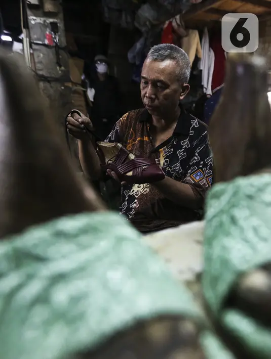 Pekerja menyelesaikan pembuatan sepatu di industri rumahan daerah Kuningan, Jakarta Selatan, Jumat (22/1/2020). Pemerintah melalui Kementerian Koperasi dan Usaha Kecil dan Menengah terus berupaya mendorong pemulihan UMKM di tengah pandemi COVID-19. (Liputan6.com/Johan Tallo)