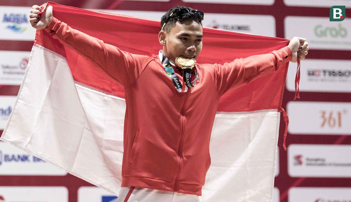 Lifter Indonesia, Eko Yuli Irawan, melakukan selebrasi usai berlaga pada Asian Games di JIExpo, Jakarta, Selasa, (21/8/2018). Eko Yuli berhasil menyumbang medali emas angkat besi putra kelas 62kg. (Bola.com/Peksi Cahyo)