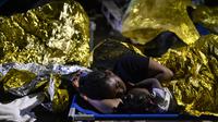 Seorang perempuan dan seorang anak tidur di luar pusat penerimaan migran Lampedusa, Sisilia, Kamis pagi, 14 September 2023. (AP Photo/Valeria Ferraro)