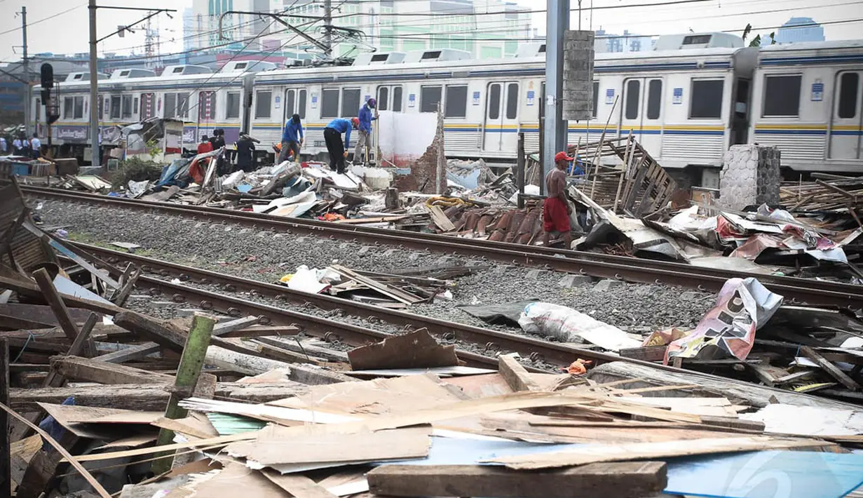 Para petugas meratakan bangunan liar saat pembongkaran di pinggiran rel kawasan Tanah Abang, Jakarta, Kamis (7/8/14). (Liputan6.com/Faizal Fanani)