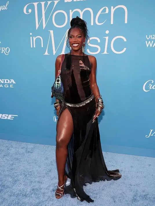 Doechii Penyanyi berbakat Doechii tampil memikat dengan sleeveless sheer dress berwarna hitam yang dilengkapi dengan detail high slit, menampilkan kesan edgy dan glamor dalam satu tampilan. [@billboard].