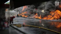 Petugas pemadam kebakaran berusaha memadamkan api yang melalap gudang di Jalan Kampung Bandan, Ancol, Jakarta Utara, Kamis (5/7). Gudang yang terbakar berisikan ban kontainer. (Liputan6.com/Faizal Fanani)
