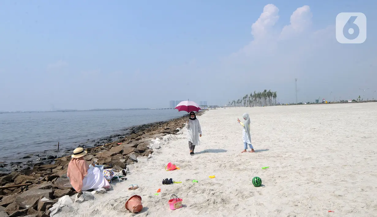 Warga bermain di hamparan pasir putih White Sand Beach, Pantai Indah Kapuk (PIK) 2, Jakarta Utara, Sabtu (5/6/2021). Hamparan pasir putih buatan sepanjang sekitar 4 Km menjadi salah satu destinasi warga Jabotabek untuk berlibur. (merdeka.com/Arie Basuki)
