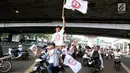 Relawan capres dan cawapres nomor urut 01 Joko Widodo atau Jokowi dan Ma'ruf Amin mengibarkan bendera saat konvoi menuju lokasi debat Pilpres 2019 di Jakarta, Minggu (17/2). Massa konvoi menggunakan sepeda motor, bus, dan truk. (Liputan6.com/JohanTallo)