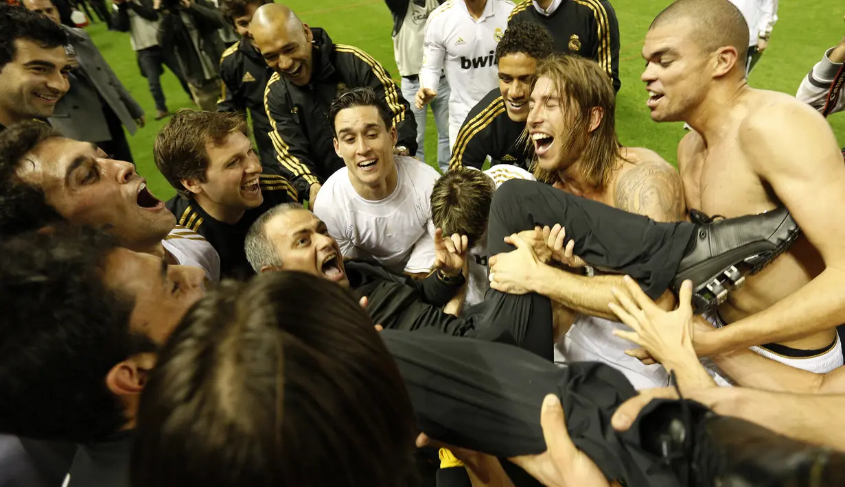 Selebrasi pelatih Real Madrid, Jose Mourinho (tengah) bersama para pemainnya usai memastikan gelar Liga Spanyol 2011/2012 setelah laga menghadapi Athletic Bilbao di San Mames Stadium, Bilbao (2/5/2012). Jose Mourinho tercatat pernah dua kali menyeberang ke klub rival di Liga Spanyol dan Inggris. Di Spanyol, ia pernah menjadi asisten pelatih Louis van Gaal di Barcelona selama 4 musim sejak 1996/1997 hingga 1999/2000 dan menjadi pelatih Real Madrid selama 3 musim sejak 2010/2011 hingga 2012/2013. (AFP/Cesar Manso)