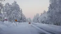 Salju dan embun beku menutupi jalan dan lanskap di desa Vittangi di kota Kiruna, Swedia utara, yang suhunya turun hingga -38,9 derajat Celcius pada pagi hari, Rabu (3/1/2024). (Emma-Sofia OLSSON / TT NEWS AGENCY / AFP)