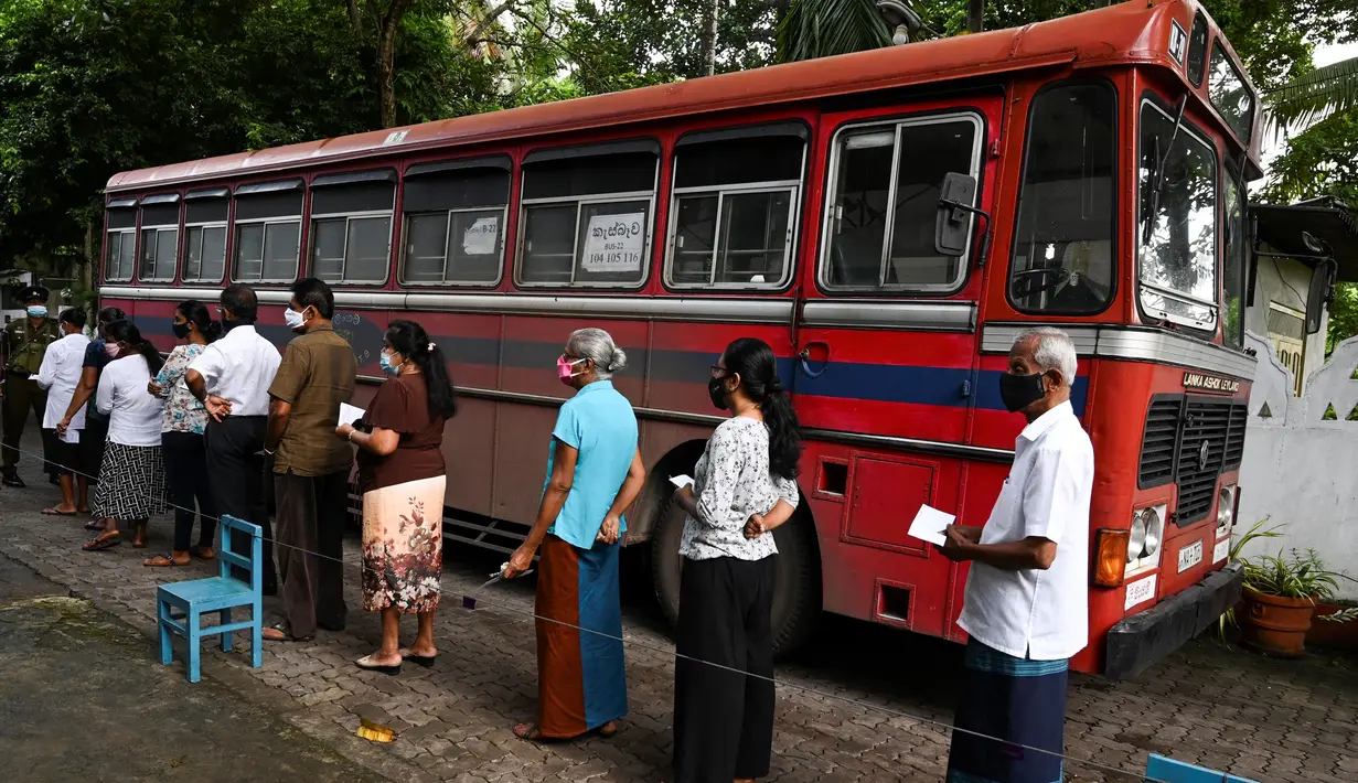 Para pemilih mengenakan masker saat antre di luar tempat pemungutan suara di Kolombo, Sri Lanka, Rabu (5/8/2020). Sri Lanka menggelar pemilihan parlemen di tengah pandemi COVID-19. (LAKRUWAN WANNIARACHCHI/AFP)
