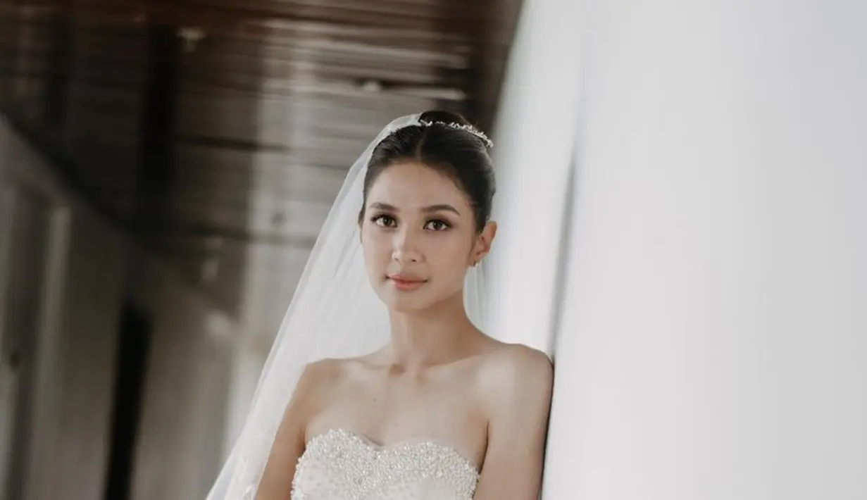 <p>Menikah di awal tahun 2023 dengan Deva Mahendra, Mikha Tambayong tampil elegan dengan gaun putih berpayet model tube milik sang ibunda. Gaun model slit tersebut dipadukan veil panjang. [@mikhatambayong]</p>
