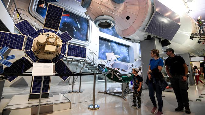 Pengunjung melihat model modul inti stasiun ruang angkasa Mir di Memorial Museum of Cosmonautics di Moskow (20/8/2019). Museum ini didedikasikan untuk eksplorasi ruang angkasa khususnya yang berkaitan dengan ruang angkasa Soviet dan Rusia. (AFP Photo/Kirill Kudryavtsev)