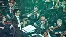 Konduktor Musik Addie MS memimpin pertunjukan konser outdoor bertema Symphony Under The Stars di Lippo Mall Kemang, Jakarta, Sabtu (28/7). Mereka membawakan sountrack film terfavorit baik dari dalam maupun luar negeri. (Liputan6.com/Fery Pradolo)