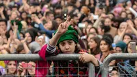 Seorang gadis mengacungkan dua jarinya saat memperingati Women's Day atau Hari Perempuan Internasional di Diyarbakir, Turki, Kamis (8/3). (ILYAS AKENGIN/AFP)