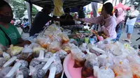 Penjual melayani pembeli makanan untuk berbuka puasa (takjil) di kawasan Pasar Lama, Kota Tangerang, Selasa (20/4/2021). Bulan Ramadhan, membuat sejumlah pedagang takjil musiman bermunculan dan menawarkan aneka makanan dan minuman untuk umat Islam yang menjalankan puasa. (Liputan6.com/Angga Yuniar)