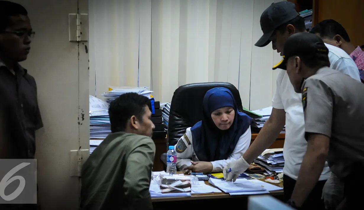 Salah satu karyawan diperiksa saat operasi tangkap tangan (OTT) terkait pungutan liar perizinan kapal di Kementerian Perhubungan, Jakarta, Selasa (11/10). (Liputan6.com/Faizal Fanani)