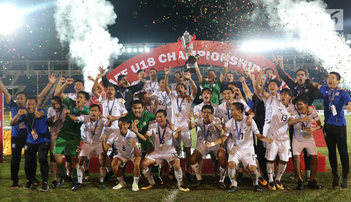 Pemain timnas Thailand U-19 mengangkat piala AFF usai menumbangkan Malaysia 2-0 pada partai final di Stadion Thuwunna, Myanmar, Minggu (17/9). Ini menjadi gelar kelima Thailand sepanjang penyelenggaraan turnamen Piala AFF U-18. (Liputan6.com/Yoppy Renato)
