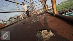 Pejalan kaki melintasi Jembatan Penyeberangan Orang (JPO) yang rusak di kawasan Tebet, Jakarta, Kamis (5/11). Kondisi jembatan yang sudah berkarat dan berlubang tersebut membahayakan pejalan kaki terutama saat malam hari. (Liputan6.com/Immanuel Antonius)
