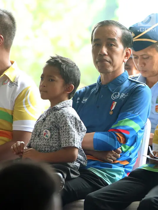 Presiden Joko Widodo memangku penyandang disabilitas Muklis Abdul Kholik saat peringatan Hari Disabilitas Internasional 2018 di Bekasi, Jawa Barat, Senin (3/12). Jokowi berjanji membangun pabrik untuk penyandang disabilitas. (Liputan6 com/Angga Yuniar)