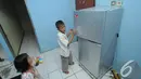 Sony Wakwaw dan adiknya melihat lemari es yang ada di rumah barunya di kawasan Cibubur, Jakarta Timur. Foto diambil pada Kamis (4/12/2014). (Liputan6.com/Herman Zakharia)