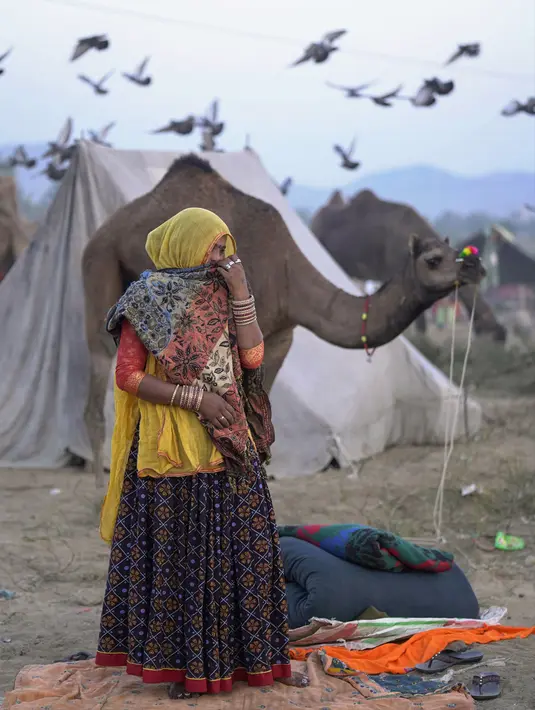 Seorang wanita bereaksi terhadap kamera saat pameran ternak tahunan di Pushkar, India, 11 November 2021. Pushkar adalah tempat ziarah Hindu populer yang juga sering dikunjungi oleh turis asing pada pameran ternak tahunannya. (AP Photo/Deepak Sharma)