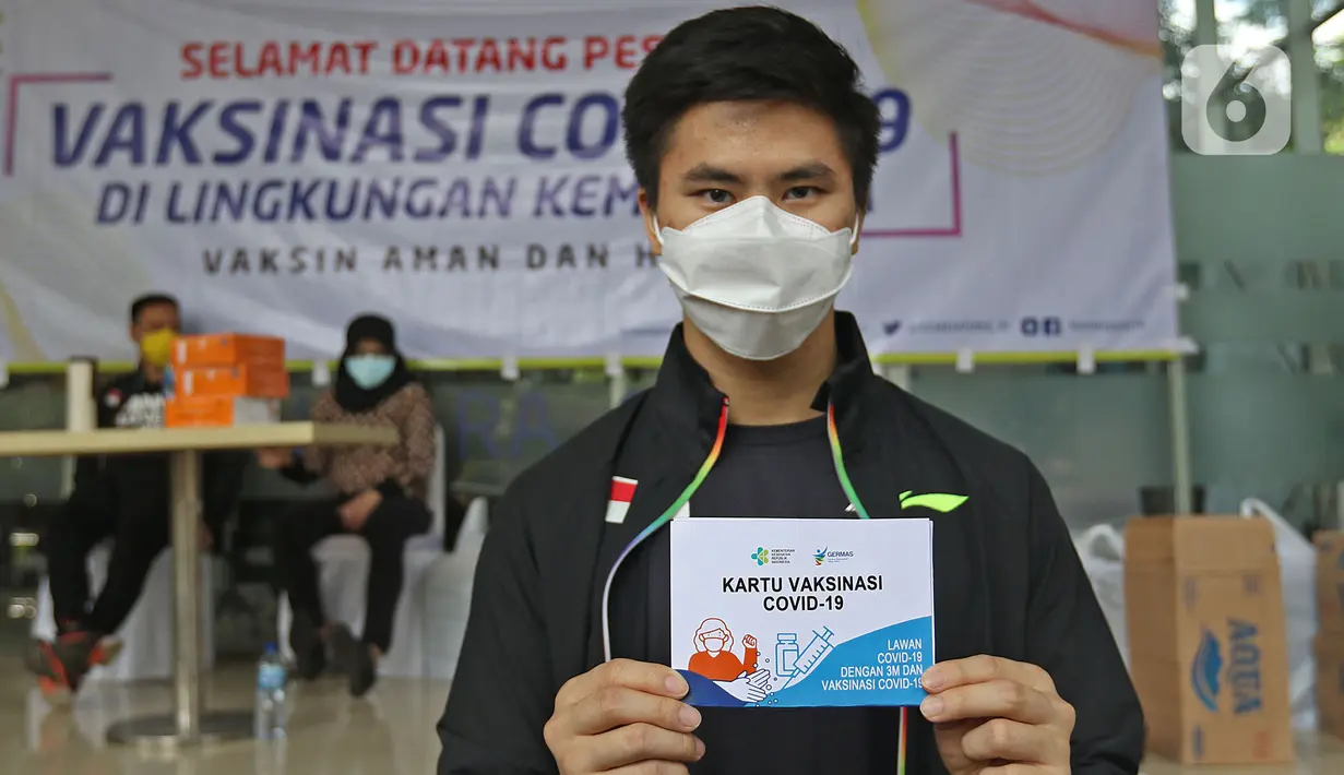 Atlet Wushu Edgar Xavier Marvelo menunjukkan kartu vaksin di Rumah Sakit Olahraga Nasional, Jakarta, Jumat (12/3/2021). Kemenpora bersama Kemenkes melakukan vaksinasi COVID-19 dosis ke-2 kepada insan olah raga nasional dengan menyasar 820 orang secara bertahap. (Liputan6.com/Herman Zakharia)