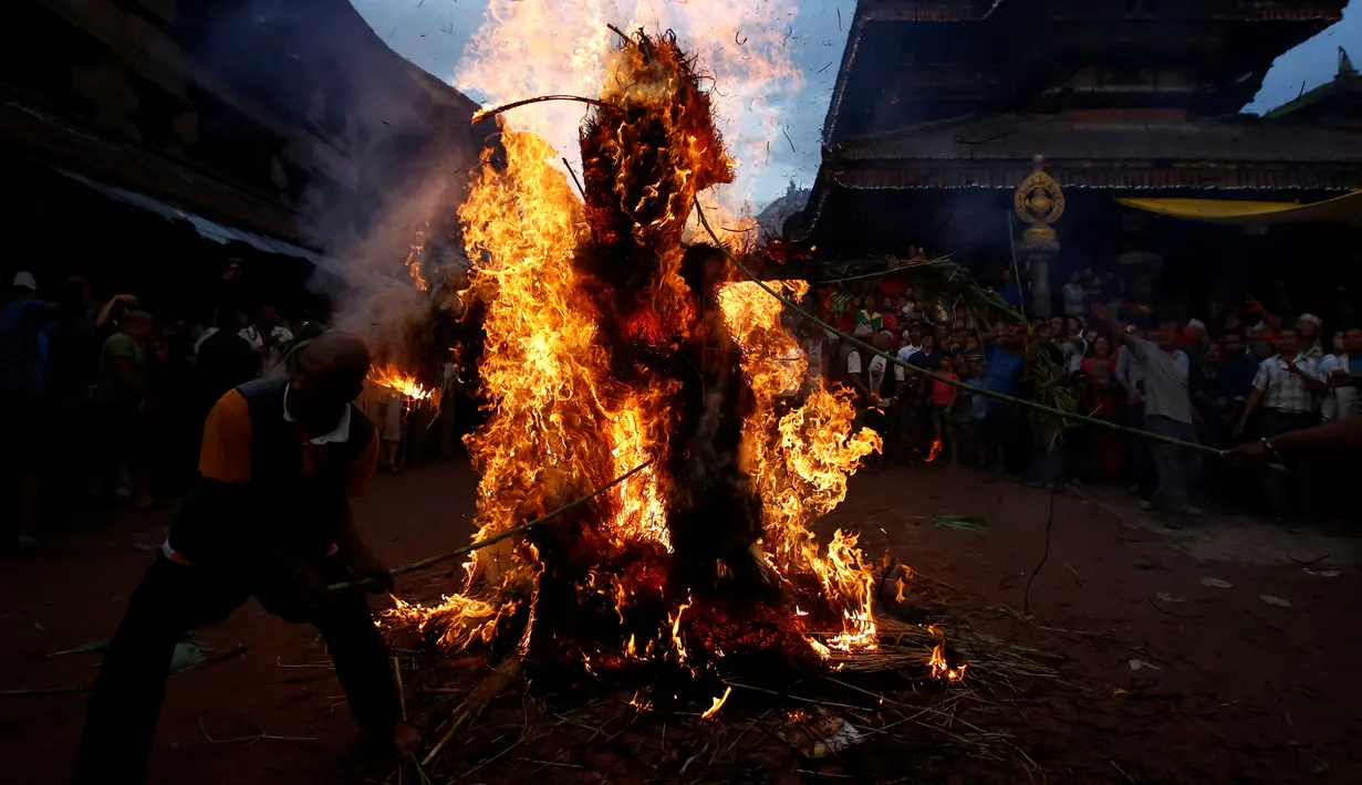 Warga membakar boneka dari jerami yang dianggap sebagai setan Ghantakarna selama Festival Ghantakarna di kota kuno Bhaktapur, Nepal, Senin (1/8).Menurut cerita setempat, setan Ghantakarna suka menculik anak-anak dan perempuan. (REUTERS/Navesh Chitrakar)