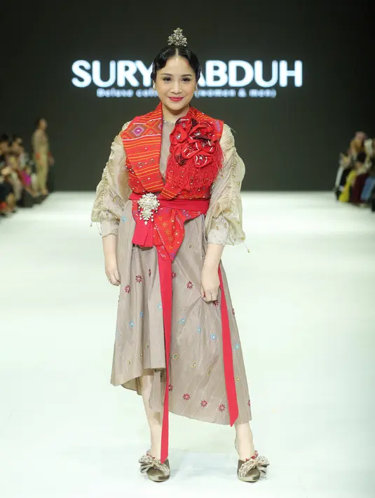 Nagita Slavina mengenakan vest ulos warna merah yang mencolok dari koleksi “Jatuh dan Cinta” milik desainer Surya Abduh. [Foto: Fimela/Bambang E. Ros]